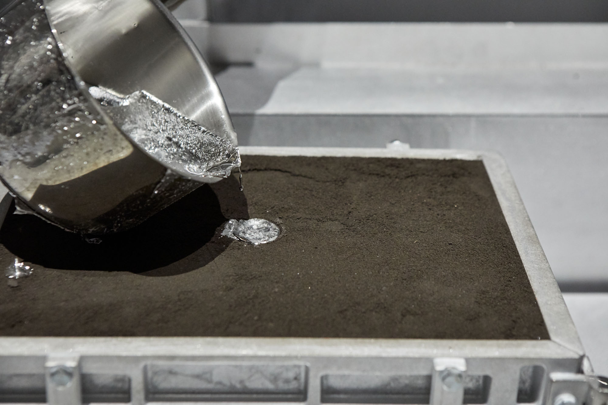 しっかりと固めた砂型のなかに、「湯」と呼ばれる熱で溶解した金属（会場ではスズを使用）を流し込んでいく。